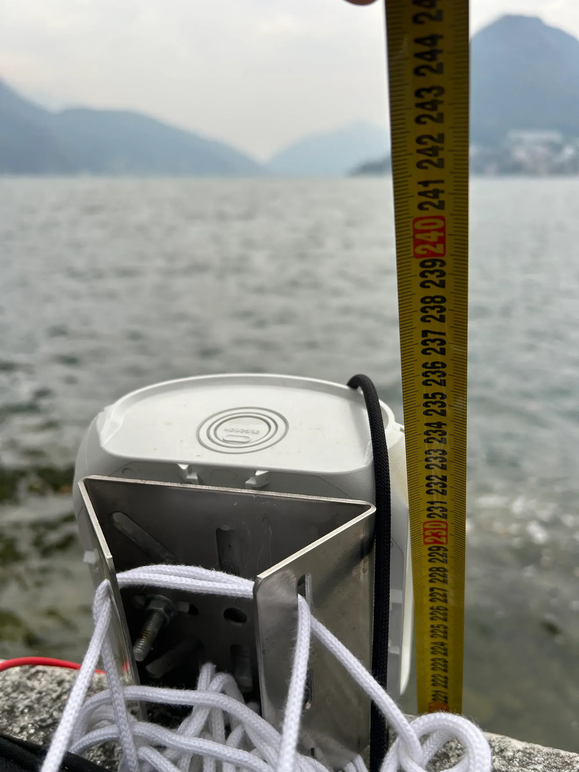A tape measure hanging from the unit's antenna down to the water surface