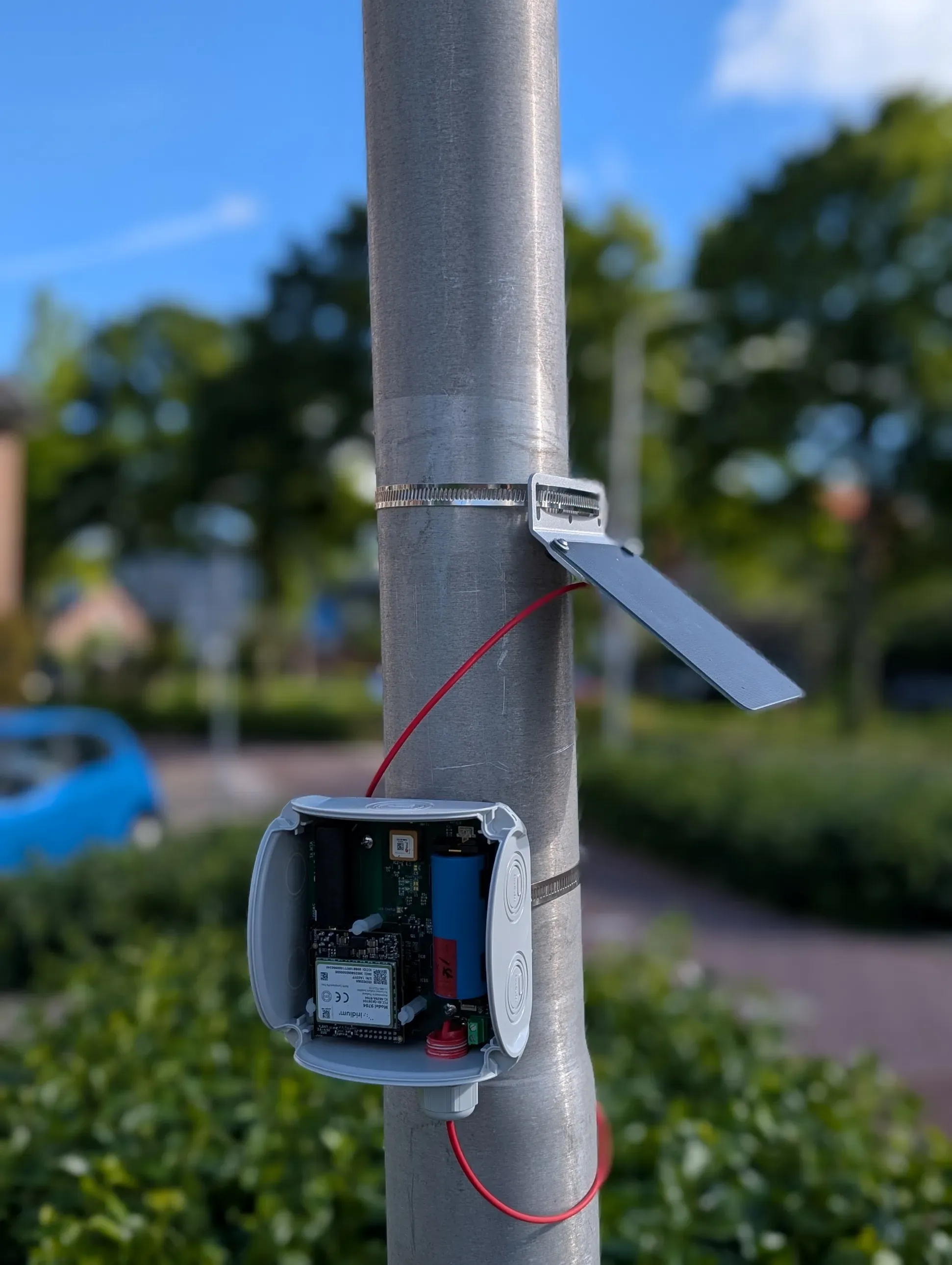 A unit with its solar panel clamped on a lamp post with hose clamps